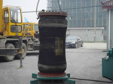 A dredge hose is on a base vertically.